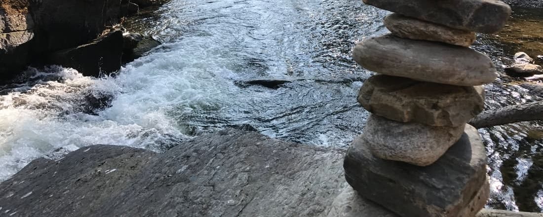 A cairn of balanced stones beside a river